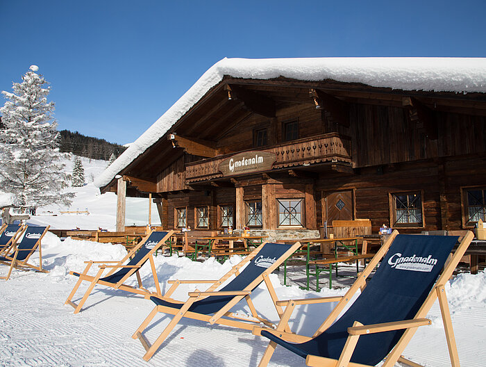 Gnadenalm mit gemütlichen Liegen an einem sonnigen Wintertag
