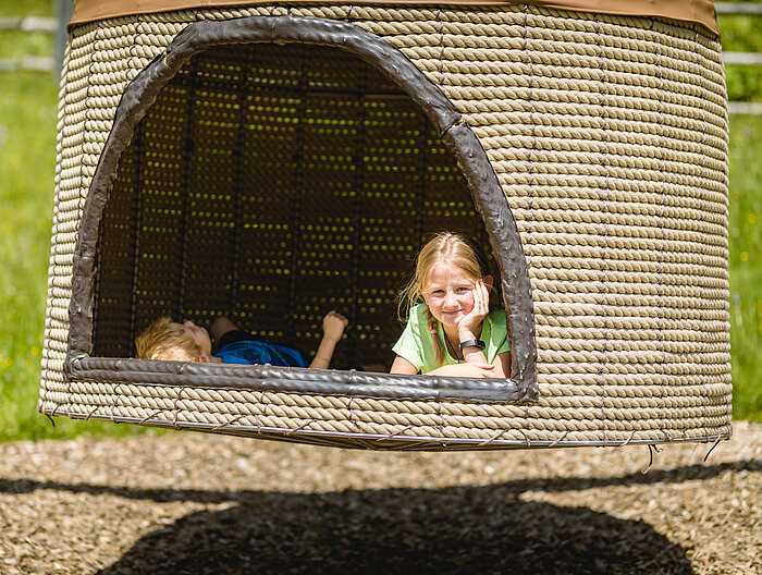 AllesAlm Zwei Kinder auf einem Sonnenbett des Erlebnisweges Alles Alm