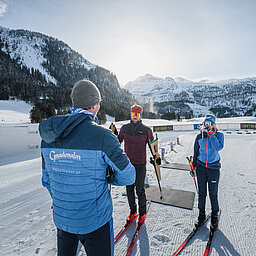 Drei Personen vor der Biathlonanlage der Gnadenalm